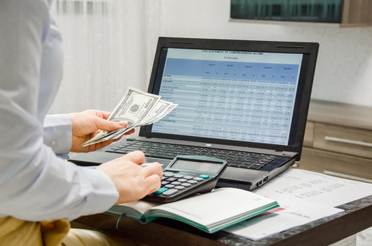  finance girl working online. counts money. the girl looks at the financial statement