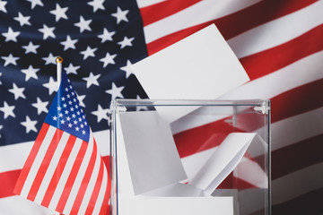 Voting box with bulletins on american flag background