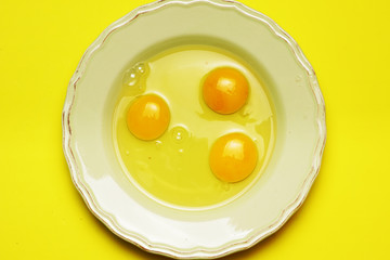 raw eggs on green plate and yellow background. cooking concept. flat lay. flat design