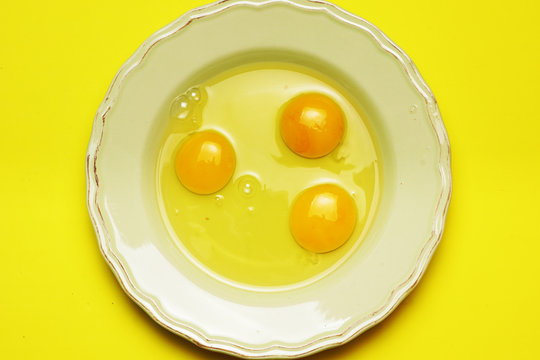 raw eggs on green plate and yellow background. cooking concept. flat lay. flat design