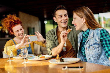 Happy man sharing dessert with is girlfriend in a cafe,