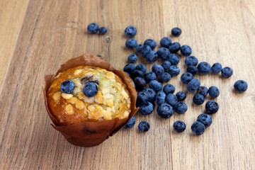 blueberry muffins with scattered berries on the wooden table