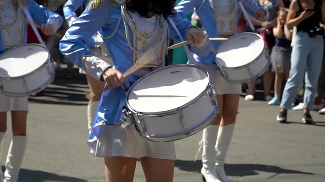 Street performance after quarantine. Close-up of female hands drummers are knocking in the drum of their sticks