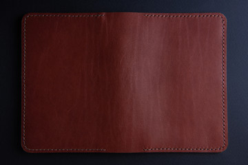 background from a piece of stitched brown leather of a rectangular shape in a black frame. Leather craft concept.
