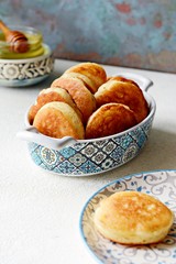 Yeast pancakes in powdered sugar  on a light background. Yeast fritters for Sunday breakfast