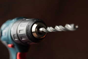 Cordless drill on brown background, close up