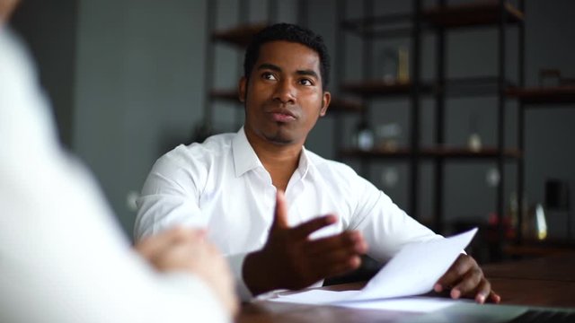 Portrait of handsome African American business man discussing business idea, increasing sales, analyzing statistics, work results report, negotiating on new business project. Shooting in slow motion.