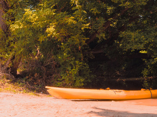 An orange boat near a stream in the woods