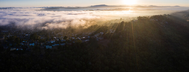 Low clouds drift in from the Pacific Ocean over the San Francisco Bay and into the East Bay hills at sunset. This marine layer develops over the ocean in the presence of a temperature inversion.