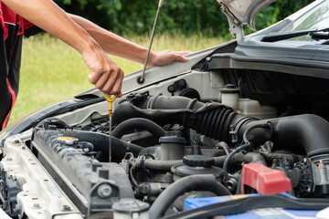 man checking the oil level in car engine