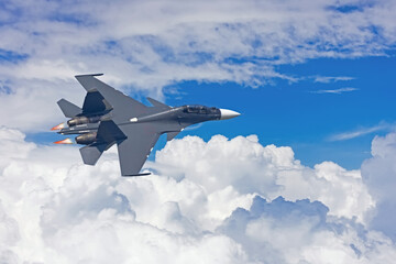 Fototapeta na wymiar Fighter combat flies afterburner high in the sky above storm cloudscape.