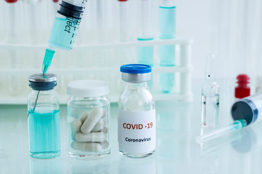 Mini medicine glass bottle and injector with medical materials on the glass table.Conceptual image of vaccine works in the laboratory.