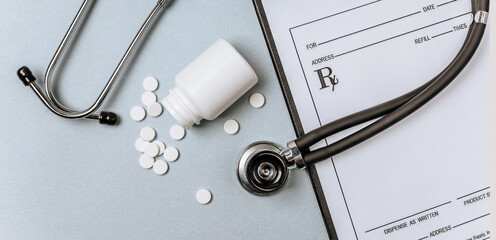 White pills, stethoscope, prescription on the doctor's table. Medicine concept. Research on prescribing the dose of medicinal products. Health care or illness. Tablet or drug in hospital or pharmacy.