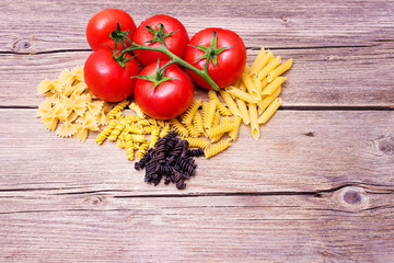 Mediterranean ingredients: ripe tomatoes on rustic wood table.