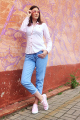 Pretty smiling brunette girl walking on the street