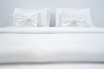 Fototapeta na wymiar Two white pillows placed at the head of the bed. Comfortable and soft pillows on bed in modern bedroom interior. Bedroom decoration