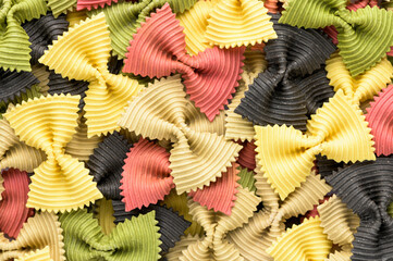 Colored bow tie pasta. Closeup multiple farfalle on white background.