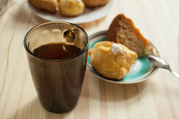 Custard cookies, tea and  tea, golden eclair filled with whipped cream