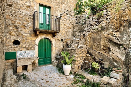 Traditional Architecture Stone House Of Sicily In Old Street Of Mistretta Village: Door, Balcony, Wash-house, Jar With Prickly Pear And Bycicle