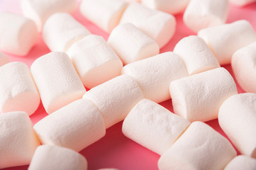 Fototapeta na wymiar Marshmallows on a pink background close up and copy space. Marshmallow top view on a pink background.