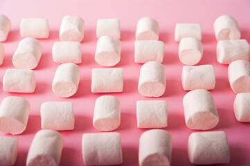 Marshmallows on a pink background close up and copy space. Marshmallow top view on a pink background.