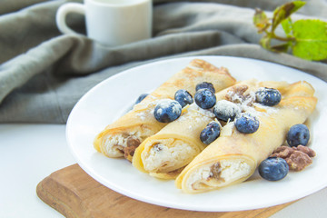 A healthy breakfast of pancakes, walnut, berries, butter, and honey.