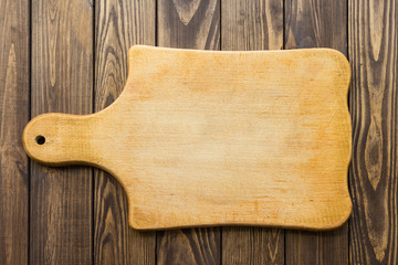 wooden cutting board with a handle on a wooden table.