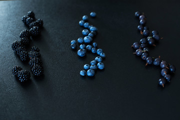 Mix set layout of different types of black berries on a black table. Stylish seasonal vitamins