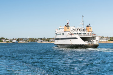 Fototapeta na wymiar Huge car ferry sailing into a harbour on a clear autumn day