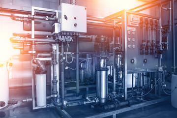 Automatic treatment and filtration of drinking water in factory, industrial background in blue...