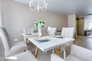 served table with a bouquet of roses in interior of modern luxure guest room in studio apartments in minimalistic style