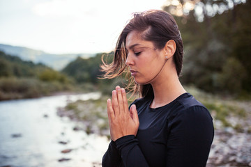 Healthy woman practice yoga on river shore