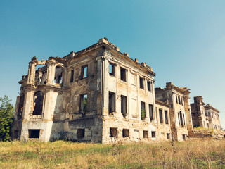 Mystical Interior, ruins of facade of an abandoned ruined building of an ancient castle 18th century. Old ruined walls, corridor with garbage and mud. Ruins Ancient historic building destroyed by war