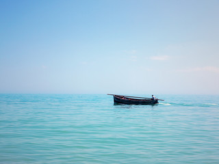 Мinimalist silhouette of fishing boats and fishermen in the calm waters of the sea in the second half of the day. Minimal style with colorful clouds and sky background.