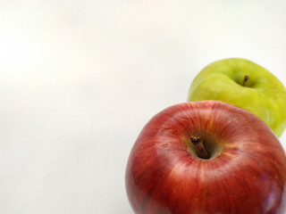 macro view of a red and a green apple on a white background