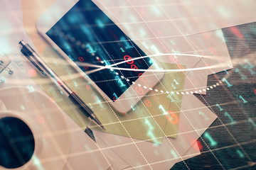 Multi exposure of forex graph hologram over desktop with phone. Top view. Mobile trade platform...