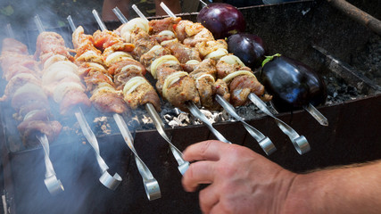 Grilled kebab cooking on metal skewer. Roasted meat cooked at barbecue.Traditional eastern dish, shish kebab. Grill on charcoal and flame, picnic, street food