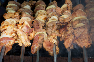 Grilled kebab cooking on metal skewer. Roasted meat cooked at barbecue.Traditional eastern dish, shish kebab. Grill on charcoal and flame, picnic, street food