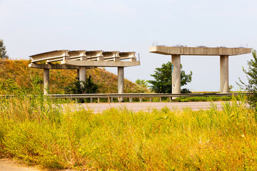 Abandoned unfinished bridge over the motorway. Overpass. The construction of the bridge. The destroyed bridge.