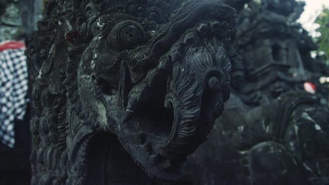 Dragon face statue at entrance of stone Hindu Temple in Bali Indonesia