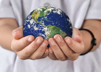 Environment day concept, Earth in child hands. Elements of this image furnished by NASA