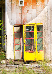 Yellow phone booth. Abandoned city Chernobyl radioactive contamination. Consequences of looting and vandalism after an explosion. People left city during disaster