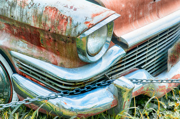 Blood red rustic vintage car relic abandoned in a field