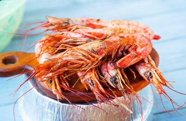 Various seafood on the shelves of the fish market. Marinated fried mussels, shrimp, octopus, conch shell, grilled fish cooked over a fire on the street. Street trade.