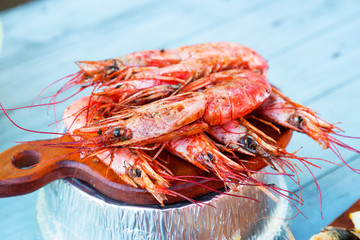 Various seafood on the shelves of the fish market. Marinated fried mussels, shrimp, octopus, conch shell, grilled fish cooked over a fire on the street. Street trade.