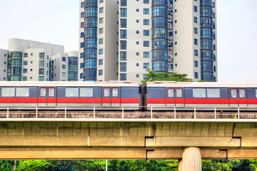 Singapore subway train on elevated tracks through a public housing estate