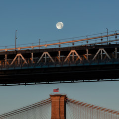 Full moon over Brooklyn and Manhattan bridges at sunrise 