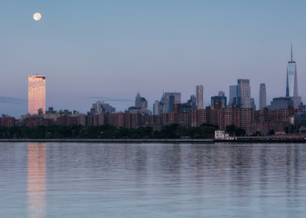 Fototapeta premium View on Downtown Manhattan from East river at sunrise with full moon set .