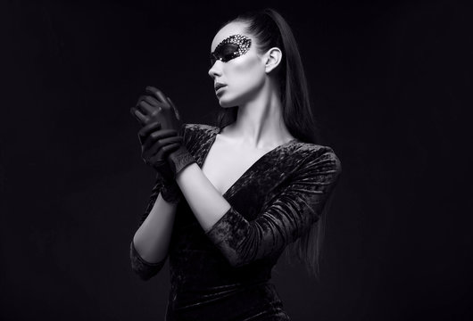 Elegant brunette woman in beautiful purple dress and sequins mask glove up