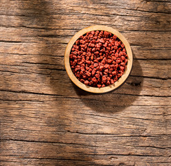 Bixa Orellana - annatto organic seeds in the wooden bowl